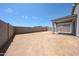 Expansive, undeveloped backyard with a covered patio, and block wall surround at 18219 W Daley Ln, Surprise, AZ 85387