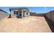 Large backyard featuring a covered patio, block fence, and low-maintenance desert landscaping at 18219 W Daley Ln, Surprise, AZ 85387