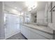 Bright bathroom with dual sinks, granite countertops, and a glass-enclosed shower at 18219 W Daley Ln, Surprise, AZ 85387