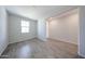 View of the bedroom with wood-style tile flooring, a window, and neutral paint at 18219 W Daley Ln, Surprise, AZ 85387