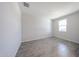 Bright bedroom featuring wood-style tile flooring and a window for natural light at 18219 W Daley Ln, Surprise, AZ 85387