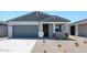 Charming single-Gathering home featuring a desert landscape, a two-car garage and a covered front entryway at 18219 W Daley Ln, Surprise, AZ 85387