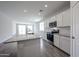 Stylish kitchen with an island, stainless steel appliances, granite countertops, and plenty of natural light at 18219 W Daley Ln, Surprise, AZ 85387