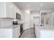 Bright kitchen features white cabinetry, stainless steel appliances, and a center island with granite countertops at 18219 W Daley Ln, Surprise, AZ 85387