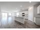 Spacious open-concept kitchen featuring an island, white cabinetry, and modern lighting at 18219 W Daley Ln, Surprise, AZ 85387