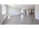 Bright, open-concept living room flows into the kitchen, featuring hard flooring and modern lighting at 18219 W Daley Ln, Surprise, AZ 85387