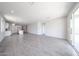 Spacious living room with tile flooring, leading to sliding glass doors, adjacent to a kitchen at 18219 W Daley Ln, Surprise, AZ 85387
