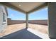 A concrete covered patio overlooking a large dirt backyard with cinderblock perimeter fence at 18219 W Daley Ln, Surprise, AZ 85387