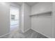 Compact walk-in closet with carpeted flooring, rod storage, and convenient access to the bathroom at 18219 W Daley Ln, Surprise, AZ 85387