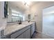 Bathroom featuring dual granite-topped vanity and glass-enclosed walk-in shower at 18236 W Daley Ln, Surprise, AZ 85387