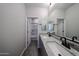 Bright bathroom with double vanity, granite counters, wood tile floor and tub with shower at 18236 W Daley Ln, Surprise, AZ 85387