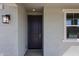 A welcoming front entrance featuring a modern light fixture and stylish, dark-stained door at 18236 W Daley Ln, Surprise, AZ 85387