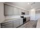 Stylish kitchen with gray cabinetry, granite countertops, and stainless steel appliances at 18236 W Daley Ln, Surprise, AZ 85387
