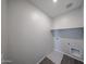 Clean laundry room with tile floors and white shelf at 18236 W Daley Ln, Surprise, AZ 85387