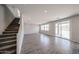 Open-concept living room and stairs featuring tile flooring and natural light at 18236 W Daley Ln, Surprise, AZ 85387