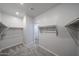 Spacious walk-in closet with extensive built-in shelving, soft carpet and neutral walls at 18236 W Daley Ln, Surprise, AZ 85387