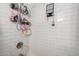 Updated shower featuring white subway tile surround, a handheld shower head, and storage shelving at 2040 S Longmore -- # 9, Mesa, AZ 85202