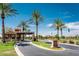 Welcoming community entrance with palm trees and a clear blue sky at 21093 N Willow Rd, Maricopa, AZ 85138