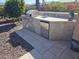 Outdoor kitchen with a built-in grill, stainless steel doors, and counter space with a sink and mini fridge at 21093 N Willow Rd, Maricopa, AZ 85138