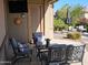 Comfortable outdoor seating on a covered patio with a mounted television, sun decoration and landscaped backyard at 21093 N Willow Rd, Maricopa, AZ 85138