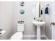 Bright powder room featuring a pedestal sink, modern fixtures, and stylish decor at 21093 N Willow Rd, Maricopa, AZ 85138