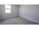 Comfortable bedroom featuring soft carpeting, neutral walls, and a sunlit window at 22035 N Rummler Ln, Maricopa, AZ 85138