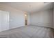 Spacious bedroom with neutral carpet and paint and a glimpse of an en-suite bathroom at 22035 N Rummler Ln, Maricopa, AZ 85138