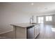 Bright kitchen island boasts a speckled granite countertop and stainless steel dishwasher in an open-concept space at 22035 N Rummler Ln, Maricopa, AZ 85138