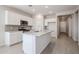 Modern kitchen features white cabinets, granite countertops, stainless steel appliances, and stylish tile flooring at 22035 N Rummler Ln, Maricopa, AZ 85138