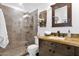 Bathroom featuring a granite countertop, undermount sink, vanity and tiled shower with a glass door at 2219 E Catalina Dr, Phoenix, AZ 85016