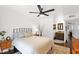 Light-filled bedroom with wood flooring, white shiplap, ceiling fan, and ensuite bathroom at 2219 E Catalina Dr, Phoenix, AZ 85016
