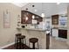 Kitchen with dark wood cabinets, granite countertops, breakfast bar, and pendant lighting at 2219 E Catalina Dr, Phoenix, AZ 85016