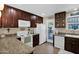 Functional kitchen featuring granite countertops, white appliances, and dark wood cabinets, offering style and efficiency at 2219 E Catalina Dr, Phoenix, AZ 85016