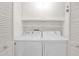 Well-organized laundry room with white washer and dryer, complemented by ample shelving for storage solutions at 2219 E Catalina Dr, Phoenix, AZ 85016
