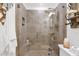 Tiled shower with glass doors, a built-in shelf, and a rainfall shower head at 2219 E Catalina Dr, Phoenix, AZ 85016