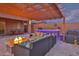 Entertaining backyard area with a covered patio, fire pit, outdoor bar, and a cozy seating area at 22977 E Desert Spoon Dr, Queen Creek, AZ 85142
