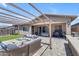 A beautifully designed backyard featuring a pergola, outdoor seating, and a built-in grill at 22977 E Desert Spoon Dr, Queen Creek, AZ 85142