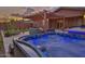 Inviting backyard featuring a hot tub with illuminated blue lighting and a shaded pergola at 22977 E Desert Spoon Dr, Queen Creek, AZ 85142