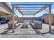 Well-designed backyard with pavers, shaded pergola, outdoor seating, and a built-in grill at 22977 E Desert Spoon Dr, Queen Creek, AZ 85142