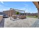 Relaxing backyard with stone pavers, comfortable outdoor seating, and a pergola for shade at 22977 E Desert Spoon Dr, Queen Creek, AZ 85142