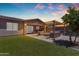 Expansive backyard with manicured lawn, outdoor dining area, and pergola with seating and grill at 22977 E Desert Spoon Dr, Queen Creek, AZ 85142