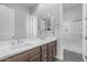 Bright bathroom with a double sink vanity, large mirror, and a view of the shower room at 22977 E Desert Spoon Dr, Queen Creek, AZ 85142