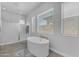 Inviting bathroom with a soaking tub, walk-in shower, and lots of natural light at 22977 E Desert Spoon Dr, Queen Creek, AZ 85142