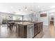 Open kitchen island with granite countertop, dishwasher, and views of the dining and living areas at 22977 E Desert Spoon Dr, Queen Creek, AZ 85142
