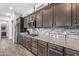 Modern kitchen featuring stylish cabinets, granite countertops, stainless steel appliances, and brick backsplash at 22977 E Desert Spoon Dr, Queen Creek, AZ 85142