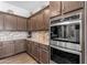 Well-appointed kitchen showcasing modern appliances, elegant cabinetry and granite countertops at 22977 E Desert Spoon Dr, Queen Creek, AZ 85142
