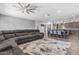 Open-concept living room featuring a gray sofa, kitchen, and dining area at 22977 E Desert Spoon Dr, Queen Creek, AZ 85142