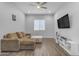 Cozy living room with a sectional sofa, television, and modern flooring at 22977 E Desert Spoon Dr, Queen Creek, AZ 85142