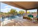 Backyard patio with covered seating area, pool, and lush desert landscape at 24042 N 170Th Ln, Surprise, AZ 85387