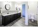 Modern bathroom with double sinks, granite countertops, stylish lighting, and a separate toilet room at 24042 N 170Th Ln, Surprise, AZ 85387